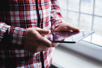 Image showing The man uses a tablet PC. Modern gadget in hand.