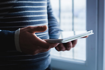 Image showing The man uses a tablet PC. Modern gadget in hand.