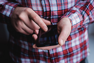 Image showing The man is using a smartphone. Modern mobile phone in hand.