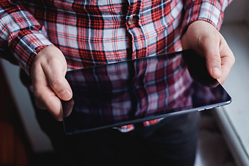 Image showing The man uses a tablet PC. Modern gadget in hand.