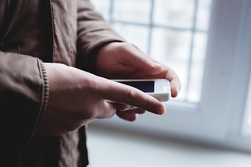 Image showing The man is using a smartphone. Modern mobile phone in hand.