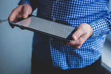 Image showing The man uses a tablet PC. Modern gadget in hand.