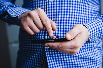 Image showing The man is using a smartphone. Modern mobile phone in hand.