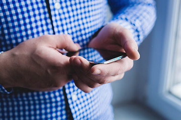 Image showing The man is using a smartphone. Modern mobile phone in hand.