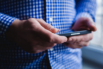 Image showing The man is using a smartphone. Modern mobile phone in hand.