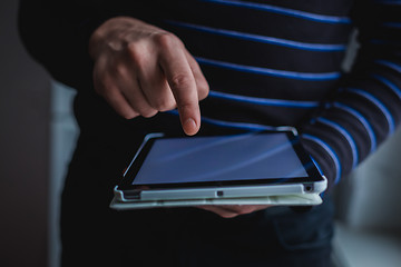 Image showing The man uses a tablet PC. Modern gadget in hand.