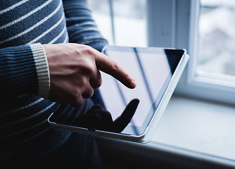 Image showing The man uses a tablet PC. Modern gadget in hand.