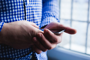 Image showing The man is using a smartphone. Modern mobile phone in hand.