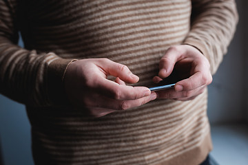 Image showing The man is using a smartphone. Modern mobile phone in hand.