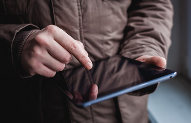 Image showing The man uses a tablet PC. Modern gadget in hand.