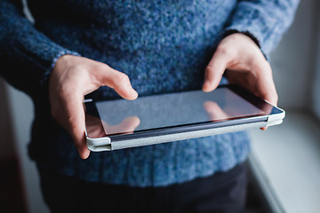 Image showing The man uses a tablet PC. Modern gadget in hand.