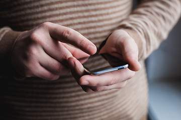 Image showing The man is using a smartphone. Modern mobile phone in hand.