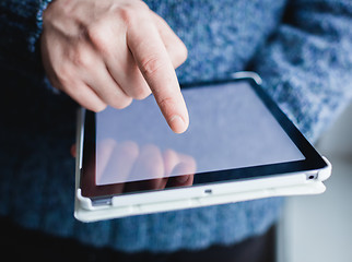 Image showing The man uses a tablet PC. Modern gadget in hand.