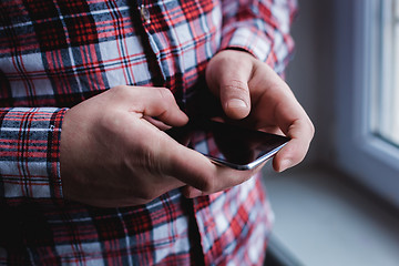 Image showing The man is using a smartphone. Modern mobile phone in hand.