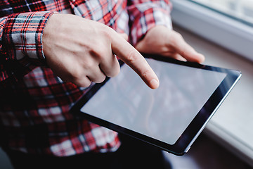 Image showing The man uses a tablet PC. Modern gadget in hand.