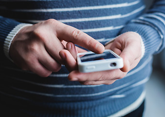 Image showing The man is using a smartphone. Modern mobile phone in hand.