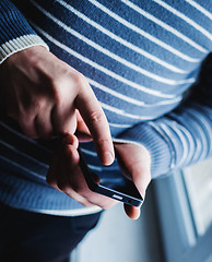 Image showing The man is using a smartphone. Modern mobile phone in hand.