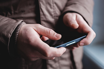 Image showing The man is using a smartphone. Modern mobile phone in hand.