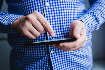 Image showing The man uses a tablet PC. Modern gadget in hand.