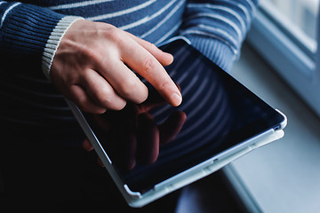 Image showing The man uses a tablet PC. Modern gadget in hand.