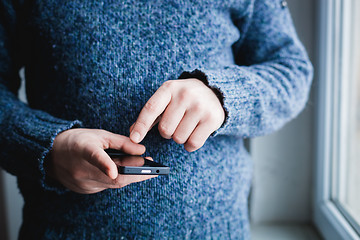 Image showing The man is using a smartphone. Modern mobile phone in hand.