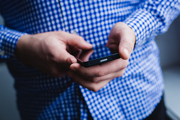 Image showing The man is using a smartphone. Modern mobile phone in hand.