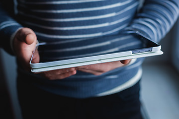 Image showing The man uses a tablet PC. Modern gadget in hand.