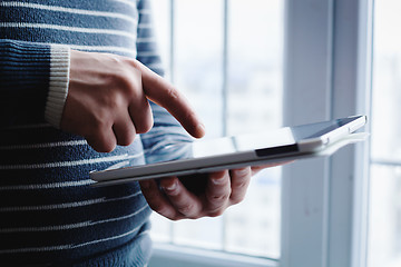 Image showing The man uses a tablet PC. Modern gadget in hand.