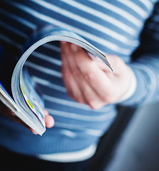 Image showing A man looks at a magazine. Press hands.