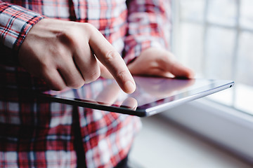 Image showing The man uses a tablet PC. Modern gadget in hand.