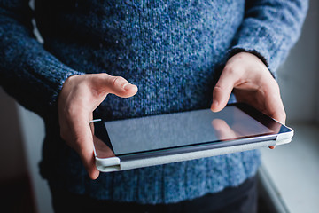 Image showing The man uses a tablet PC. Modern gadget in hand.