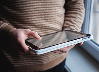 Image showing The man uses a tablet PC. Modern gadget in hand.