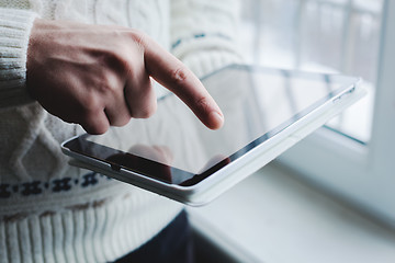 Image showing The man uses a tablet PC. Modern gadget in hand.