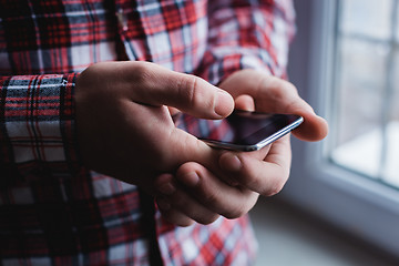 Image showing The man is using a smartphone. Modern mobile phone in hand.