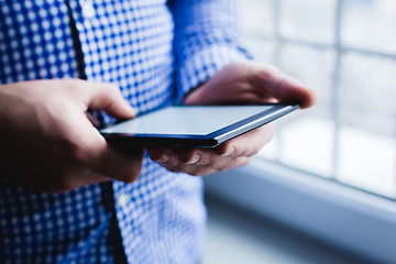 Image showing The man uses a tablet PC. Modern gadget in hand.