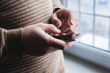 Image showing The man is using a smartphone. Modern mobile phone in hand.