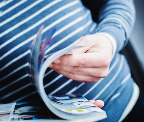 Image showing A man looks at a magazine. Press hands.