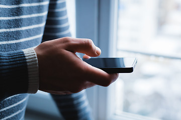 Image showing The man is using a smartphone. Modern mobile phone in hand.