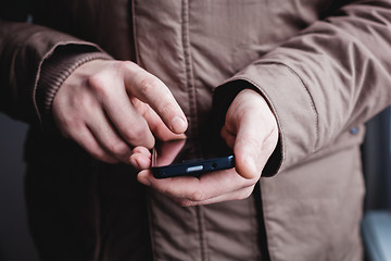 Image showing The man is using a smartphone. Modern mobile phone in hand.