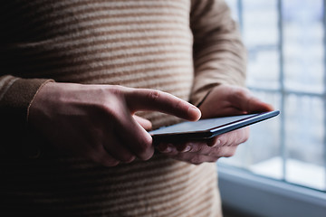 Image showing The man uses a tablet PC. Modern gadget in hand.