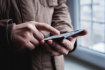 Image showing The man uses a tablet PC. Modern gadget in hand.