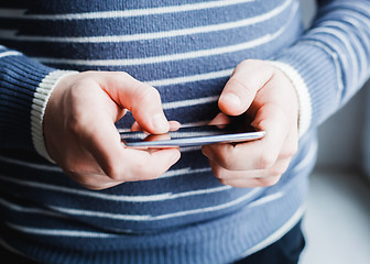 Image showing The man is using a smartphone. Modern mobile phone in hand.