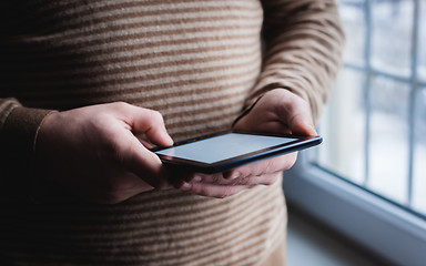 Image showing The man uses a tablet PC. Modern gadget in hand.