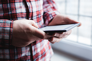 Image showing The man uses a tablet PC. Modern gadget in hand.