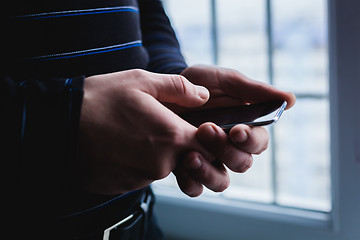 Image showing The man is using a smartphone. Modern mobile phone in hand.