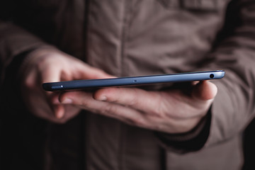 Image showing The man uses a tablet PC. Modern gadget in hand.