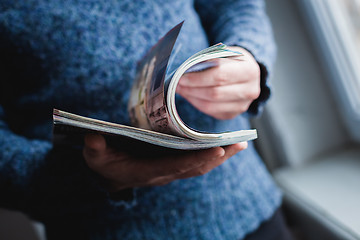 Image showing A man looks at a magazine. Press hands.