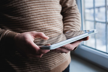 Image showing The man uses a tablet PC. Modern gadget in hand.