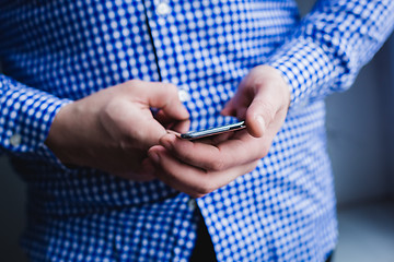 Image showing The man is using a smartphone. Modern mobile phone in hand.