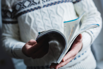 Image showing A man looks at a magazine. Press hands.